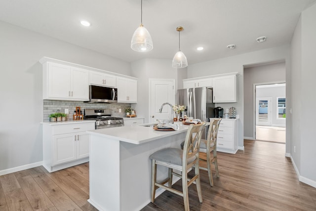 2452 Greenbriar Ln, Buffalo, MN 55313 - kitchen with appliances with stainless steel finishes, light wood-type flooring, tasteful backsplash, light countertops, and white cabinets