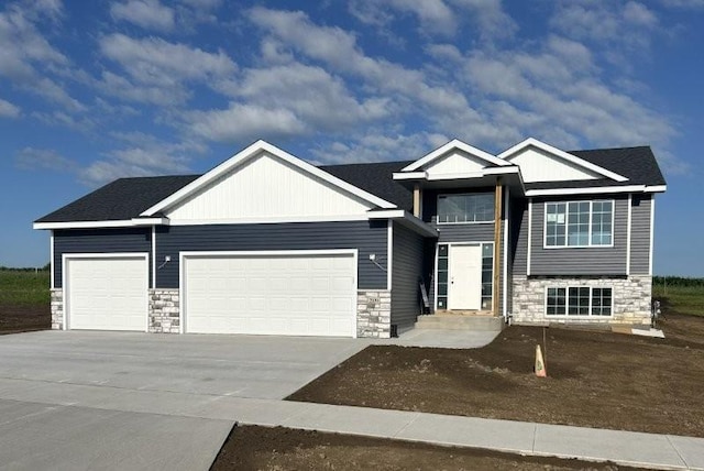 2109 6th Ave NE, Kasson, MN 55944 - view of front of home with stone siding, a garage, concrete driveway, and board and batten siding