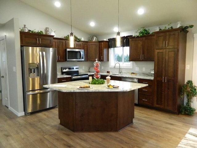 2109 6th Ave NE, Kasson, MN 55944 - kitchen featuring appliances with stainless steel finishes, light wood-style flooring, a kitchen island, vaulted ceiling, and pendant lighting