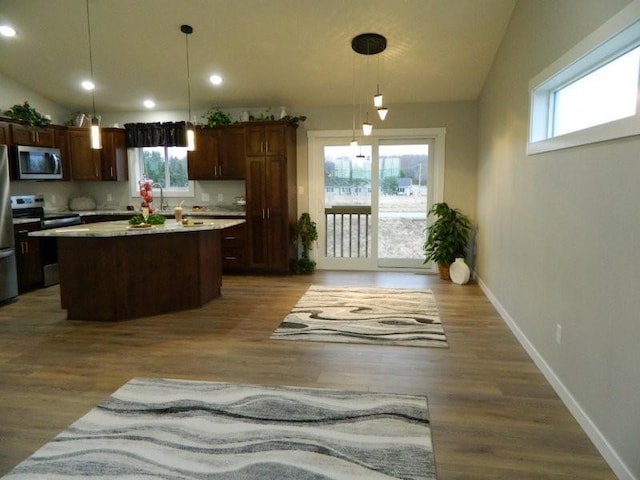 2109 6th Ave NE, Kasson, MN 55944 - kitchen featuring stainless steel appliances, healthy amount of natural light, vaulted ceiling, a center island, and light countertops