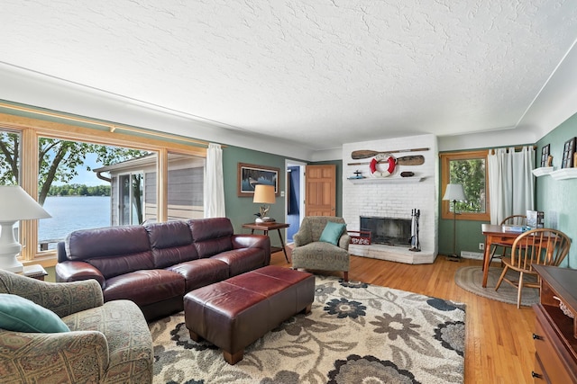 1276 County Rd Unit G, Milltown, WI 54858 - living area with a textured ceiling, wood finished floors, a fireplace, and a water view