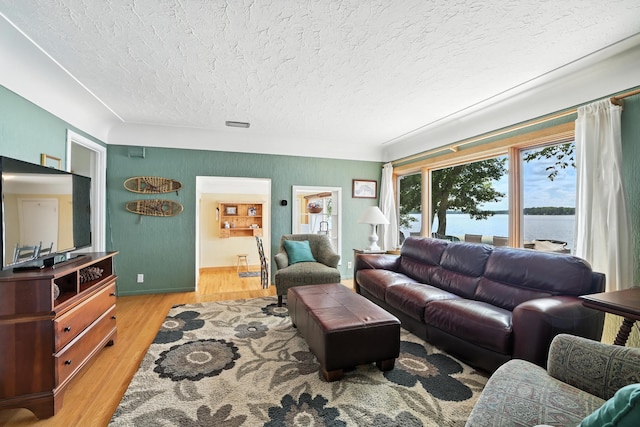 1276 County Rd Unit G, Milltown, WI 54858 - living area with a textured ceiling, light wood finished floors, and a water view