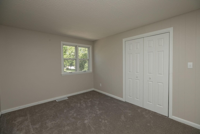 405 River St SW, Chatfield, MN 55923 - unfurnished bedroom featuring dark carpet, a textured ceiling, and a closet