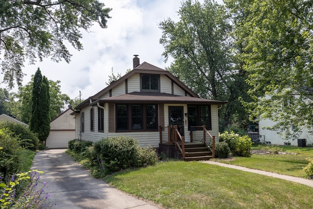 3979 Reservoir Blvd, Columbia Heights, MN 55421 - view of front facade featuring a chimney, an outdoor structure, and a front yard