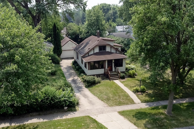 3979 Reservoir Blvd, Columbia Heights, MN 55421 - view of front facade with a front yard, a chimney, a shingled roof, an outbuilding, and covered porch