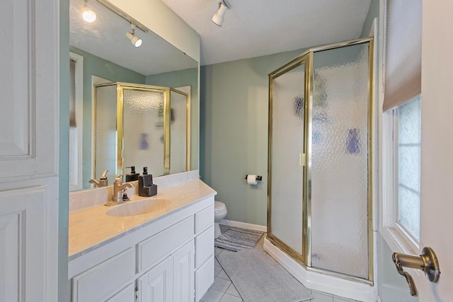 3979 Reservoir Blvd, Columbia Heights, MN 55421 - bathroom featuring rail lighting, vanity, a stall shower, and tile patterned floors