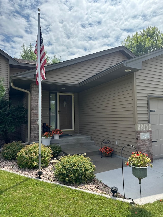 12313 Ilex St NW, Coon Rapids, MN 55448 - entrance to property featuring an attached garage and brick siding