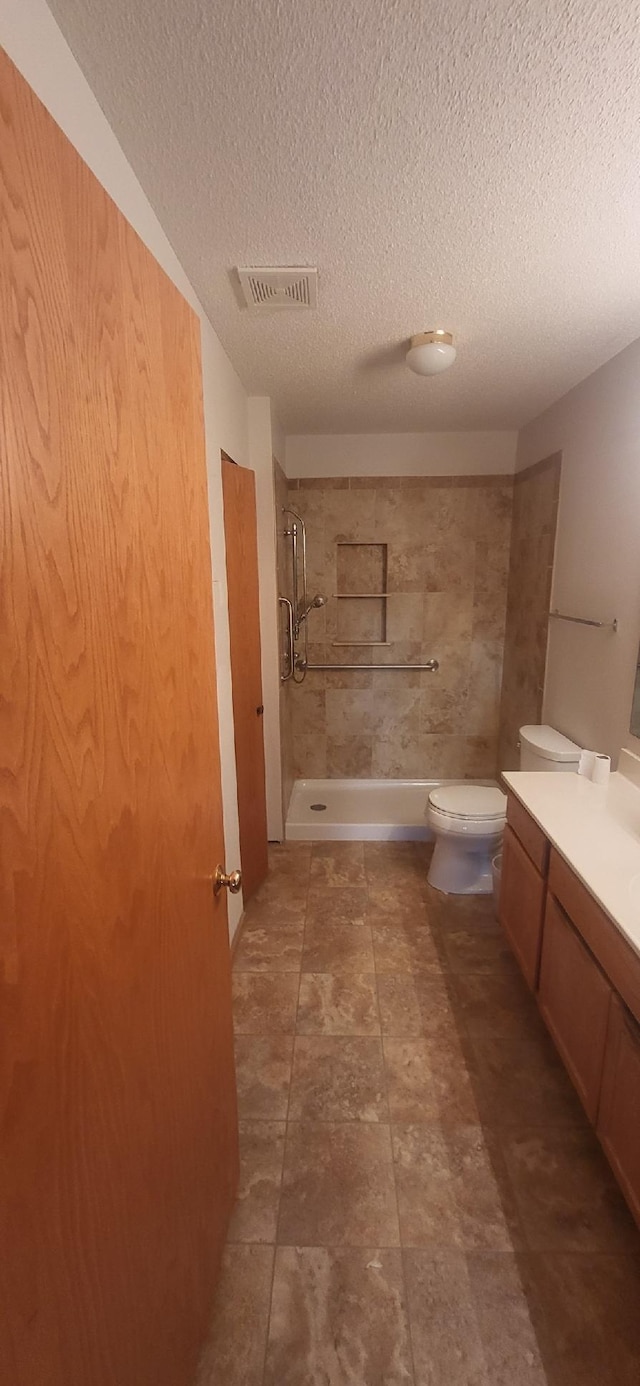 6896 Inverness Trl Unit 14, Inver Grove Heights, MN 55077 - bathroom featuring vanity, tiled shower, and a textured ceiling
