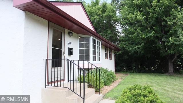6007 Vincent Ave N, Brooklyn Center, MN 55430 - entrance to property with stucco siding and a yard