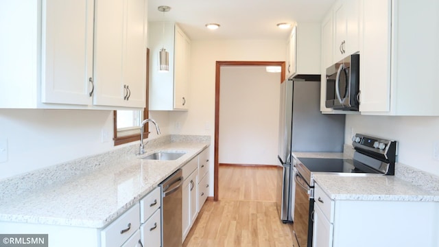 6007 Vincent Ave N, Brooklyn Center, MN 55430 - kitchen with appliances with stainless steel finishes, white cabinetry, light wood-style flooring, and light stone countertops