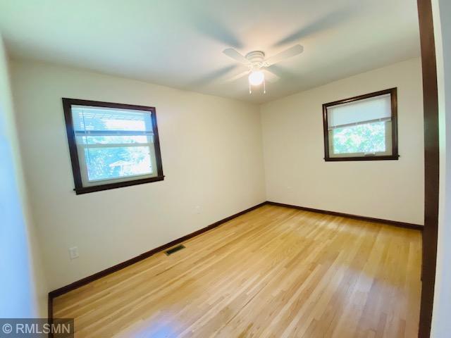 6007 Vincent Ave N, Brooklyn Center, MN 55430 - spare room featuring plenty of natural light, light wood-type flooring, and ceiling fan