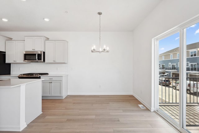 2700 Kepler Ave NE, Saint Michael, MN 55376 - kitchen featuring stainless steel microwave, a chandelier, light wood finished floors, stove, and light countertops