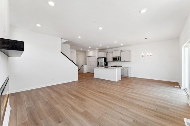 2700 Kepler Ave NE, Saint Michael, MN 55376 - unfurnished living room featuring recessed lighting, a chandelier, light wood-style floors, and stairs