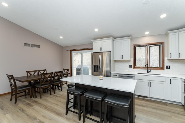 3415 Lake St NW, Rochester, MN 55901 - kitchen featuring stainless steel appliances, tasteful backsplash, lofted ceiling, recessed lighting, and a kitchen breakfast bar