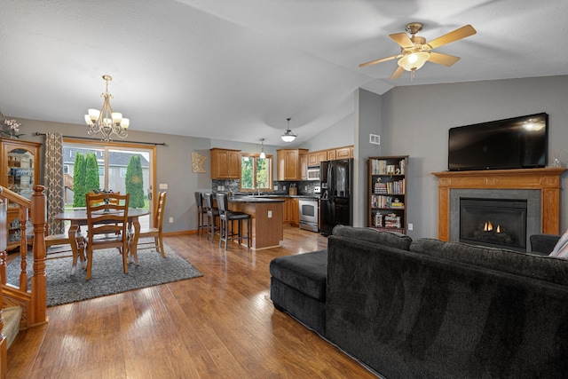 133 Uriah Ct, Mankato, MN 56001 - living area with a chandelier, light wood-type flooring, vaulted ceiling, a glass covered fireplace, and ceiling fan