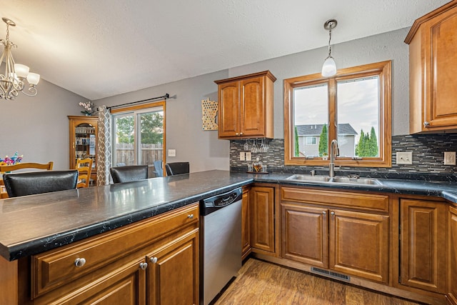 133 Uriah Ct, Mankato, MN 56001 - kitchen featuring stainless steel dishwasher, a peninsula, decorative backsplash, lofted ceiling, and light wood-style floors