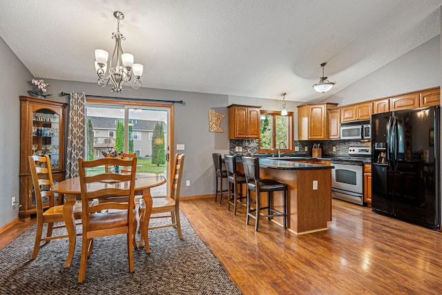 133 Uriah Ct, Mankato, MN 56001 - dining room with a chandelier, wood finished floors, a textured ceiling, and lofted ceiling