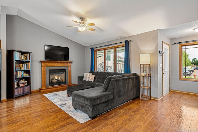 133 Uriah Ct, Mankato, MN 56001 - living room with ceiling fan, wood finished floors, vaulted ceiling, a glass covered fireplace, and a textured wall