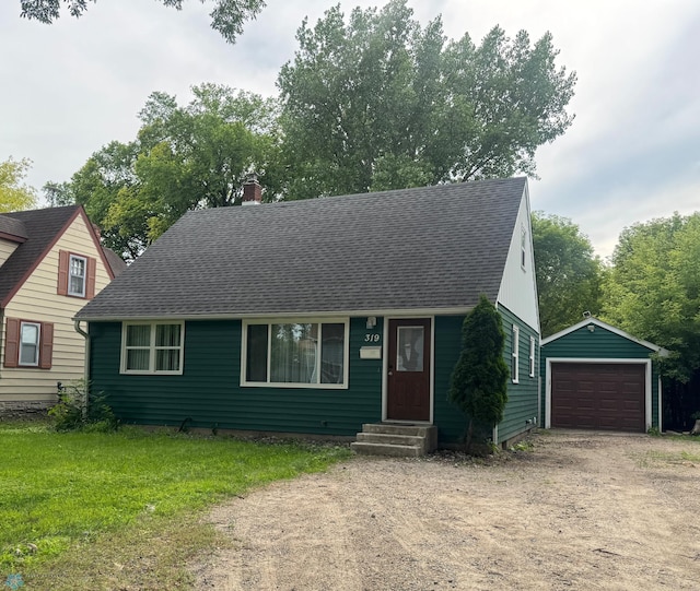 319 13th St N, Moorhead, MN 56560 - view of front facade with entry steps, a detached garage, an outbuilding, a chimney, and roof with shingles
