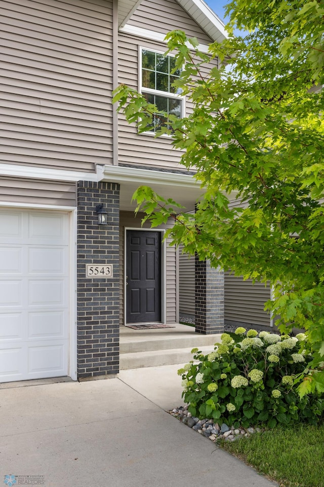 5543 Tuscan Ct S, Fargo, ND 58104 - property entrance with a garage and brick siding