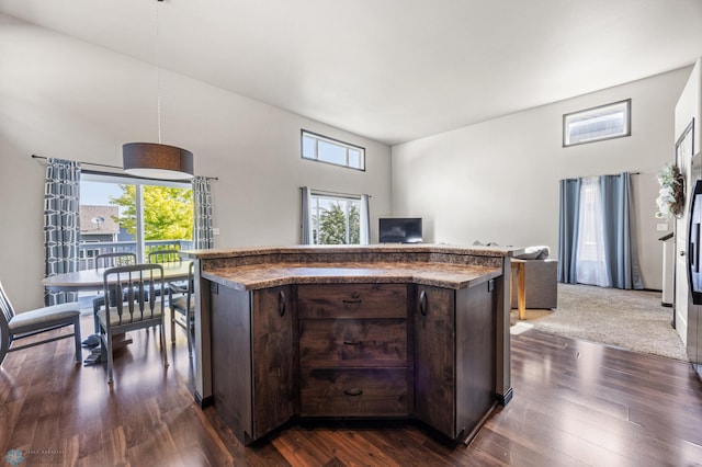5543 Tuscan Ct S, Fargo, ND 58104 - kitchen featuring dark brown cabinetry, dark wood-style flooring, decorative light fixtures, and a kitchen island