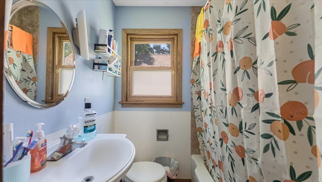806 8th St SW, Willmar, MN 56201 - bathroom featuring plenty of natural light, wainscoting, shower / tub combo with curtain, and tile walls