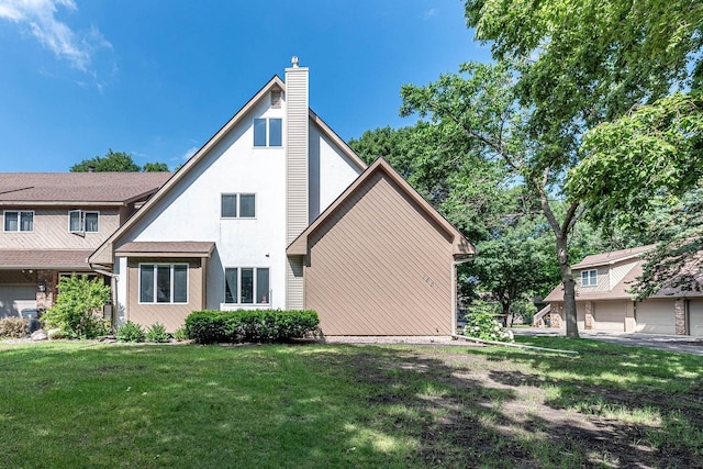 1607 Pleasant View Dr, North Mankato, MN 56003 - back of property featuring a yard, a chimney, and stucco siding