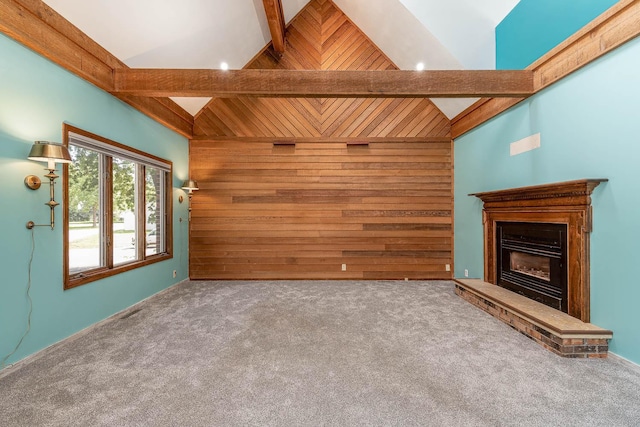 1607 Pleasant View Dr, North Mankato, MN 56003 - unfurnished living room with wood walls, beam ceiling, a fireplace with raised hearth, carpet floors, and high vaulted ceiling