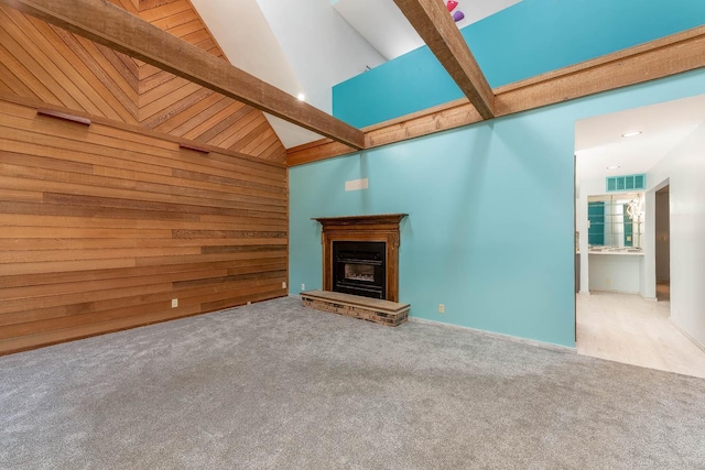 1607 Pleasant View Dr, North Mankato, MN 56003 - unfurnished living room featuring carpet flooring, wooden walls, a fireplace with raised hearth, beam ceiling, and high vaulted ceiling