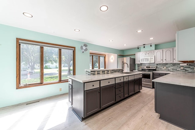 1607 Pleasant View Dr, North Mankato, MN 56003 - kitchen with stainless steel appliances, an island with sink, light wood-style flooring, light countertops, and recessed lighting