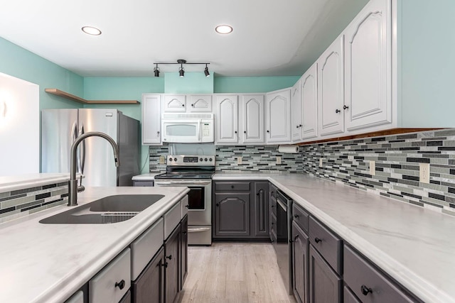 1607 Pleasant View Dr, North Mankato, MN 56003 - kitchen featuring appliances with stainless steel finishes, backsplash, white cabinets, light wood-style flooring, and recessed lighting