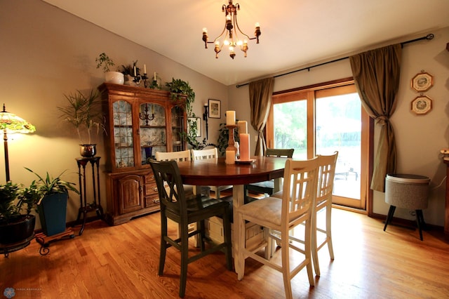 1307 Libra Ln, Fargo, ND 58104 - dining area featuring a chandelier, light wood-style flooring, and vaulted ceiling