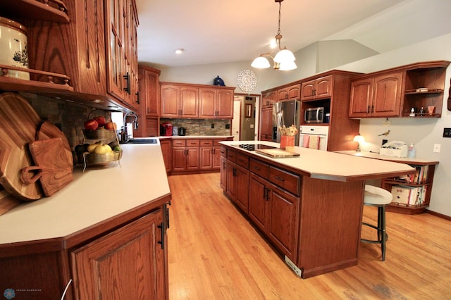 1307 Libra Ln, Fargo, ND 58104 - kitchen featuring appliances with stainless steel finishes, lofted ceiling, a center island, light countertops, and a breakfast bar