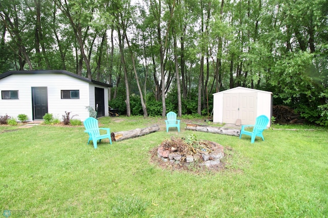 1307 Libra Ln, Fargo, ND 58104 - view of grassy yard with an outdoor fire pit and an outbuilding