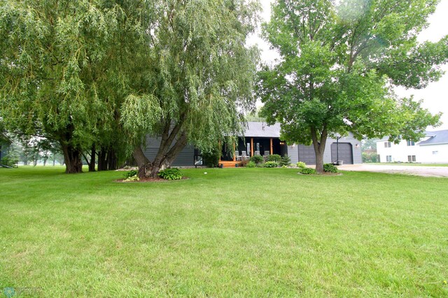 1307 Libra Ln, Fargo, ND 58104 - view of green lawn with a garage, a porch, and driveway