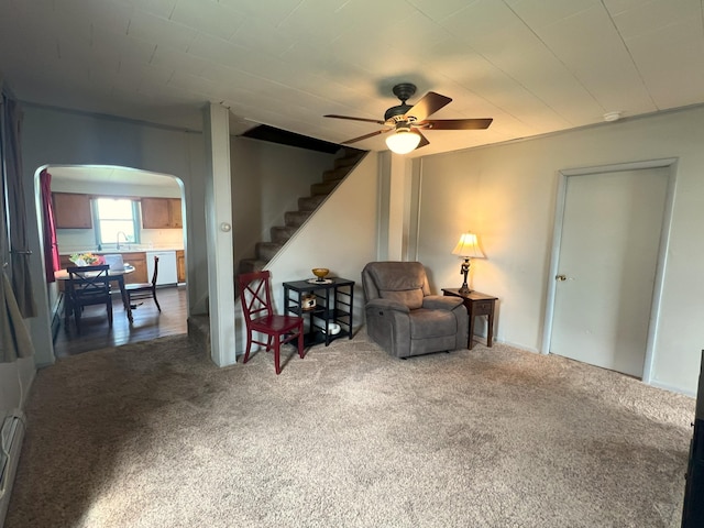 208 Benton St W, Cologne, MN 55322 - living area featuring arched walkways, carpet flooring, stairs, ceiling fan, and baseboard heating