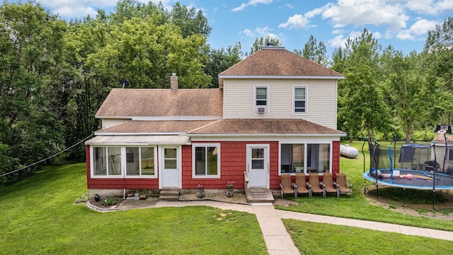 41793 Kilkenny Rd, Kilkenny, MN 56052 - view of front of property featuring a trampoline, a front lawn, a shingled roof, a chimney, and entry steps