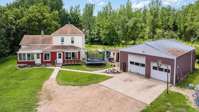 41793 Kilkenny Rd, Kilkenny, MN 56052 - view of front facade featuring concrete driveway, an outbuilding, entry steps, a trampoline, and a front lawn
