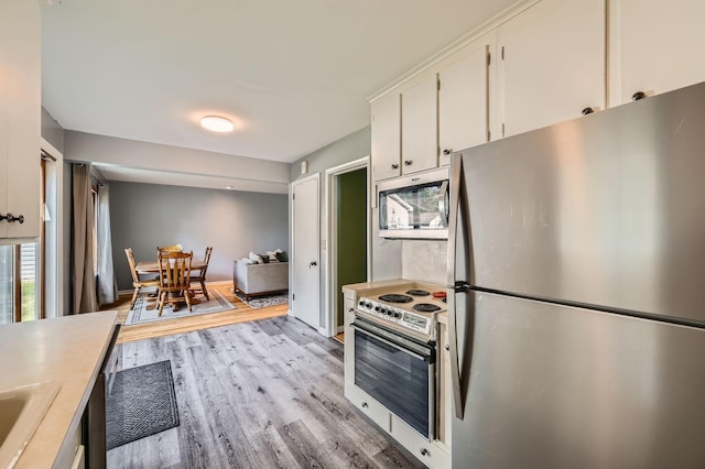 457 108th Ln NW, Coon Rapids, MN 55448 - kitchen with stainless steel appliances, white cabinetry, light countertops, and light wood-style floors