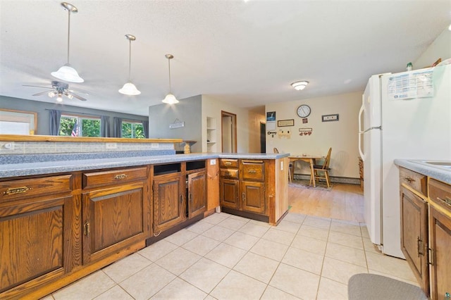 4043 Rehbein Rd, Duluth, MN 55803 - kitchen featuring brown cabinets, freestanding refrigerator, hanging light fixtures, and ceiling fan