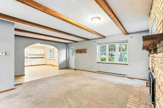 453 Van Dyke St, Saint Paul, MN 55119 - unfurnished living room with a fireplace with raised hearth, beam ceiling, arched walkways, a baseboard heating unit, and plenty of natural light