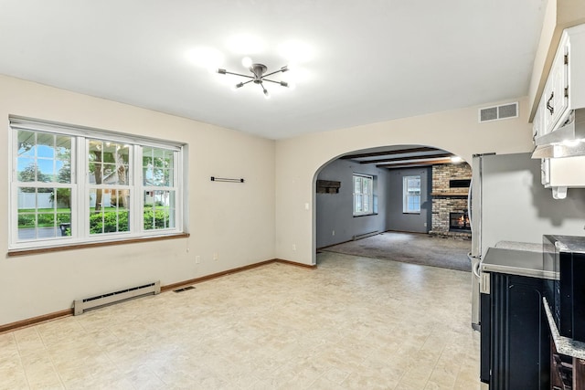 453 Van Dyke St, Saint Paul, MN 55119 - kitchen featuring a baseboard heating unit, arched walkways, a fireplace, white cabinets, and light countertops