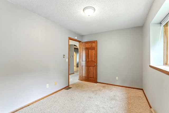 453 Van Dyke St, Saint Paul, MN 55119 - carpeted empty room with arched walkways and a textured ceiling