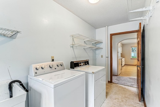 453 Van Dyke St, Saint Paul, MN 55119 - laundry room featuring washing machine and dryer, arched walkways, and a textured ceiling