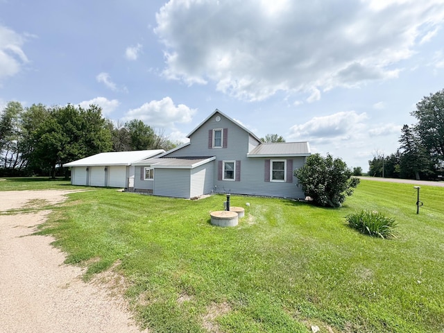 35448 200th St, Brewster, MN 56119 - view of side of property featuring driveway, a metal roof, a lawn, and a detached garage