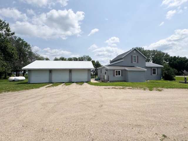 35448 200th St, Brewster, MN 56119 - view of side of property featuring a garage, an outbuilding, a metal roof, dirt driveway, and a lawn