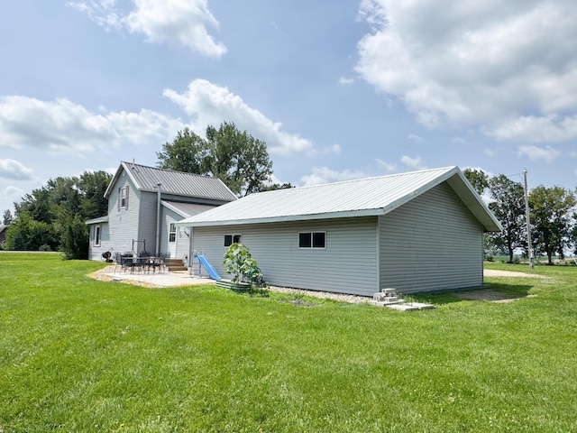 35448 200th St, Brewster, MN 56119 - back of house featuring a lawn, a patio area, a metal roof, and an outdoor structure