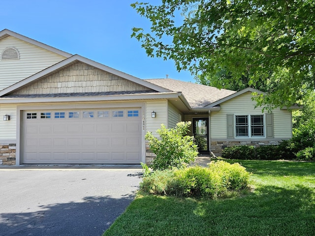 1411 Blue Jay Pl, New Richmond, WI 54017 - ranch-style home featuring stone siding, an attached garage, driveway, and a front lawn