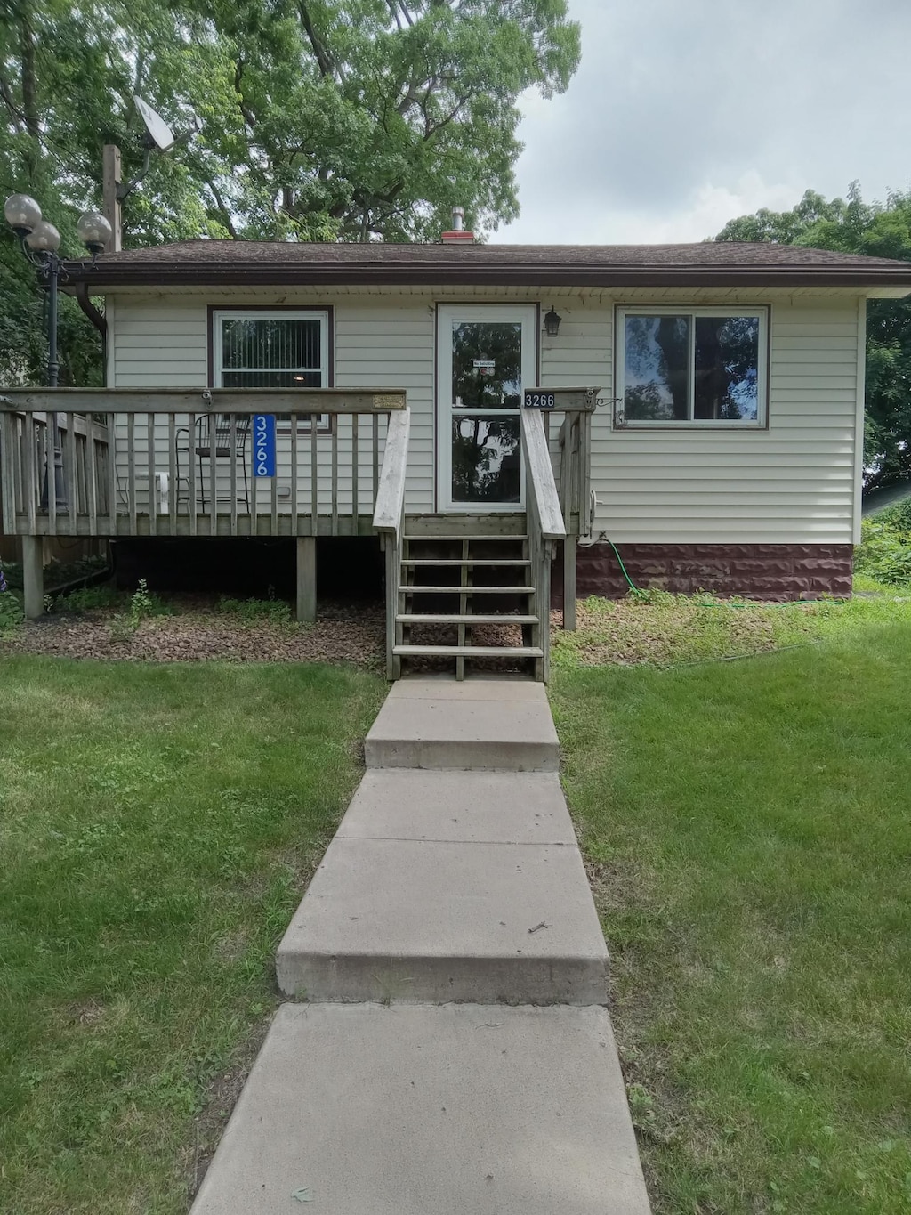 3266 Owasso Blvd, Shoreview, MN 55126 - view of front of house with a front yard, a deck, and a shingled roof