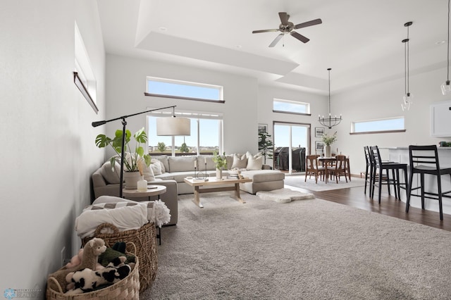 1592 69th Ave S, Fargo, ND 58104 - living area with a high ceiling, ceiling fan, dark wood-style floors, a raised ceiling, and a chandelier